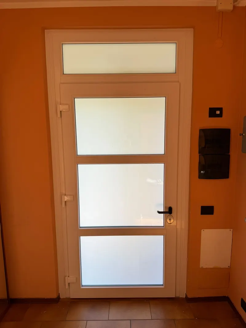 Porta d'ingresso bianca con pannelli in vetro satinato e sopraluce